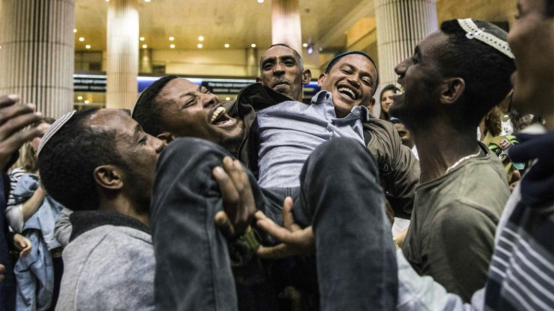 An Ethiopian Jew reunites with his family at the Ben Gurion Airport near Tel Aviv, Israel, early Feb. 5, 2019. Nearly 100 Ethiopian Jews landed in Israel in the first wave of new immigration since the government said last year that it would let some of the 8,000 remaining community members join relatives in Israel. (AP Photo/Tsafrir Abayov)