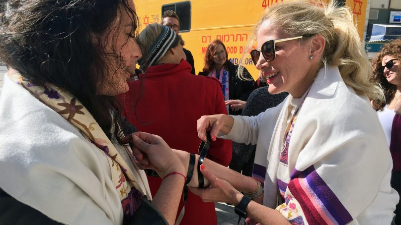 Women of the Wall board member Dina Greenberg, right, helps another woman lay tefillin during an event in Jerusalem on Feb. 3, 2019. Photo by Elizabeth Kirshner and Tammy Gottlieb/Women of the Wall