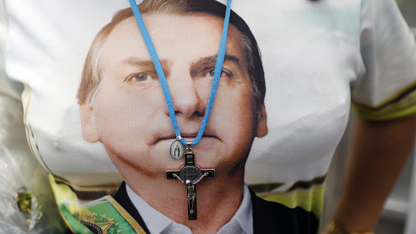 A supporter of Brazilian President Jair Bolsonaro wears a crucifix necklace over a shirt with Bolsonaro’s likeness prior to his inauguration, in Brasilia, Brazil, on Jan. 1, 2019. (AP Photo/Silvia Izquierdo)