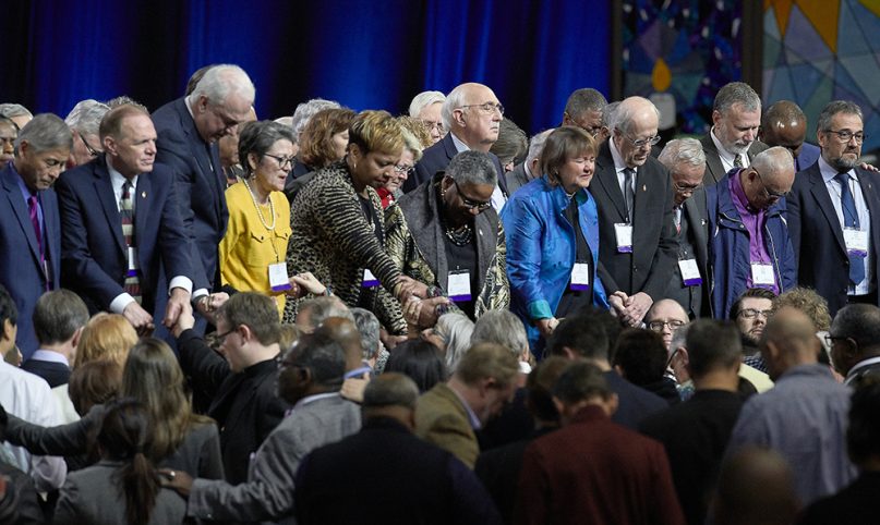 United Methodist bishops and delegates gather together to pray at the front of the stage before a key vote on church policies about homosexuality on Feb. 26, 2019, during the special session of the General Conference of the United Methodist Church, held in St. Louis, Mo. Photo by Paul Jeffrey/UMNS