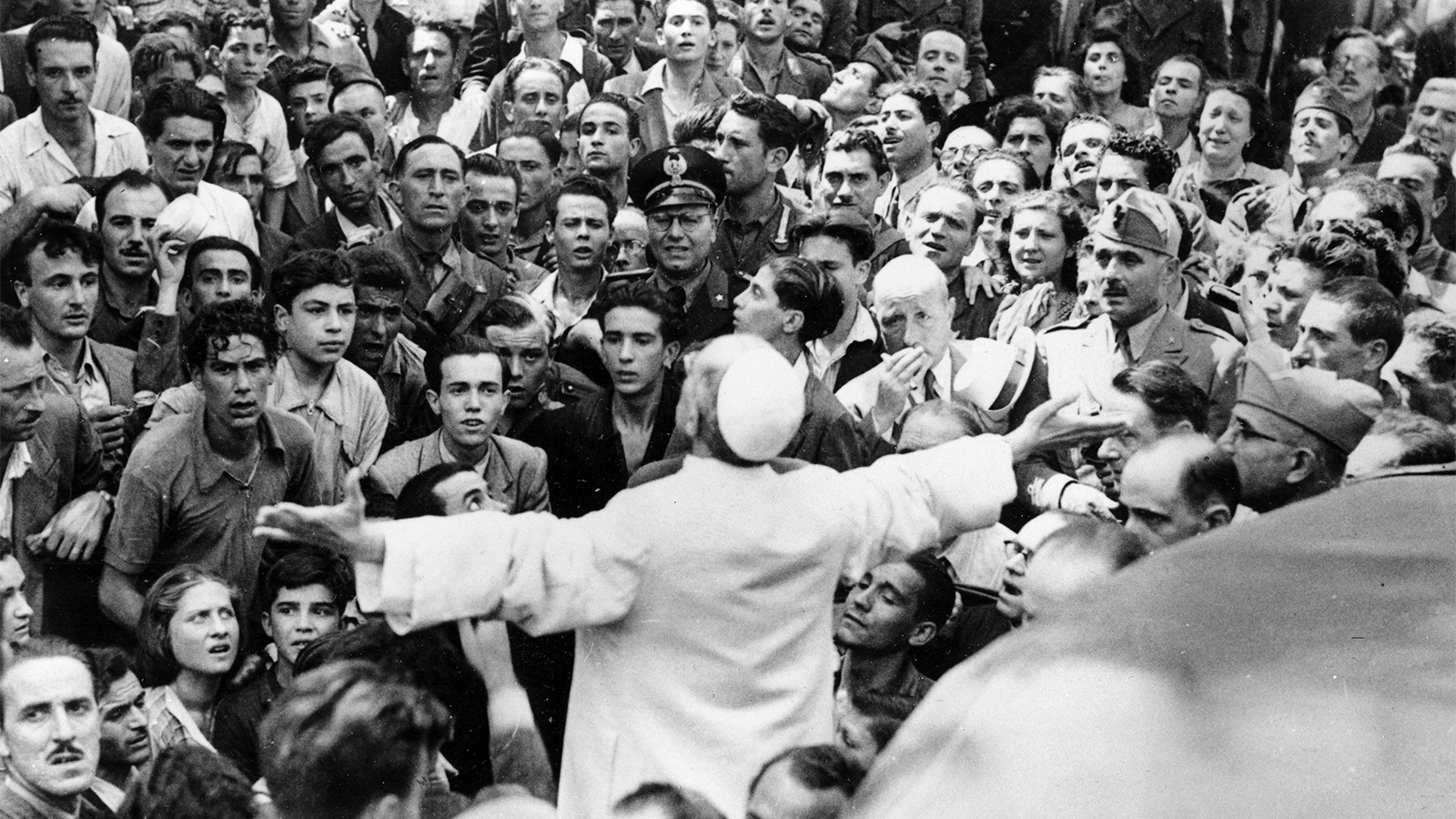 Men, women and soldiers gather around Pope Pius XII, his arms outstretched, during his inspection tour of Rome, Italy, after American air raids in World War II, on Oct. 15, 1943. (AP Photo)