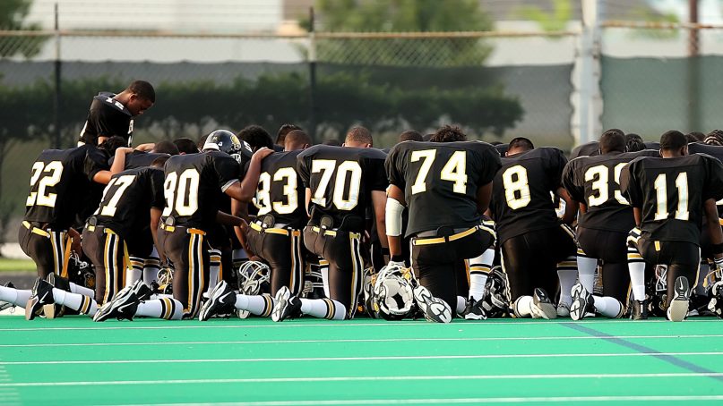 A football team prays together. Photo courtesy of Creative Commons