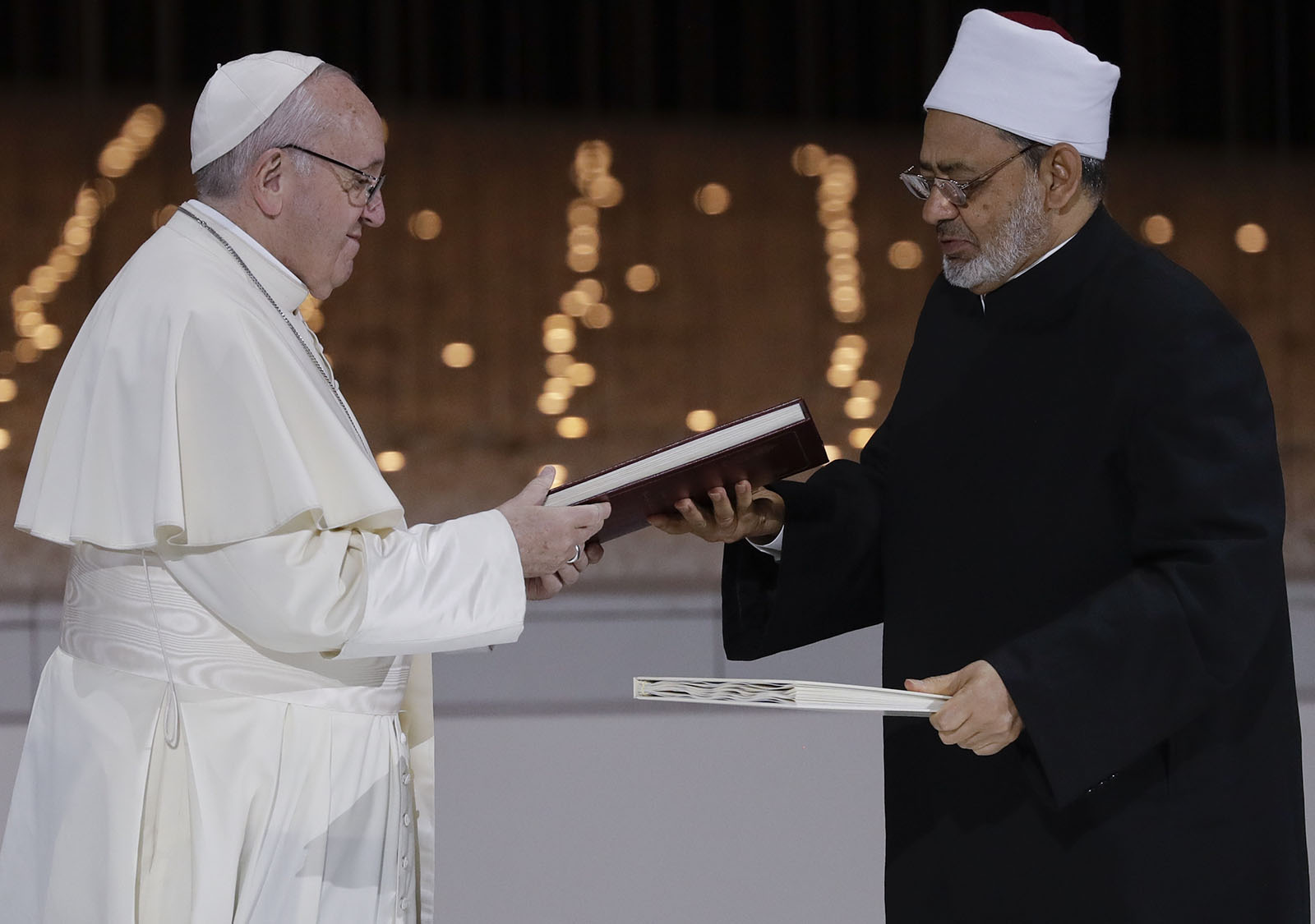 Pope Francis, left, and Sheikh Ahmed el-Tayeb, the grand imam of Egypt's Al-Azhar, exchange a joint statement on "human fraternity" after an interfaith meeting at the Founder's Memorial in Abu Dhabi, United Arab Emirates, Monday, Feb. 4, 2019. (AP Photo/Andrew Medichini)