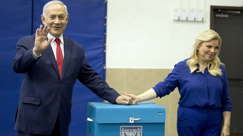 Israeli Prime Minister Benjamin Netanyahu, left, waves with his wife, Sara, after voting during Israel's parliamentary elections in Jerusalem on April 9, 2019. (AP Photo/Ariel Schalit)