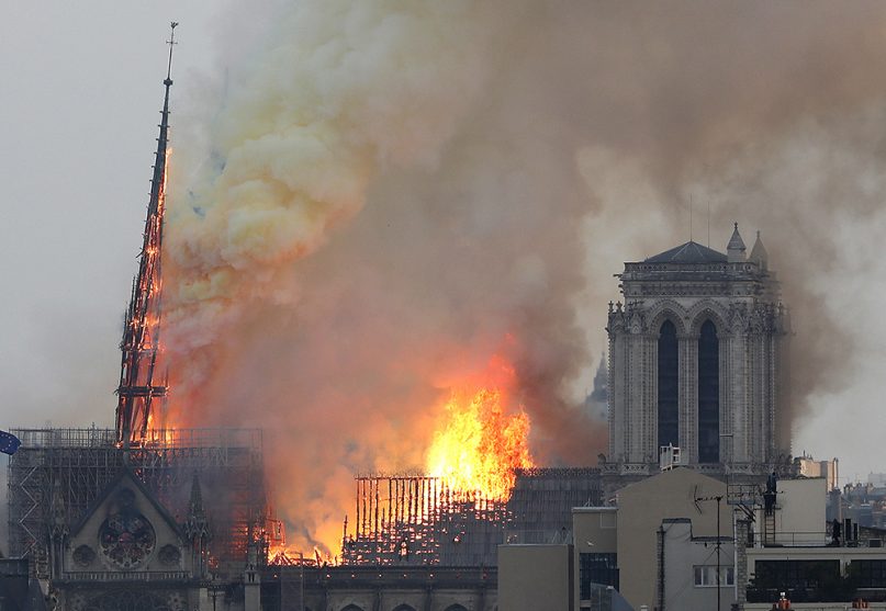 Flames rise from Notre Dame Cathedral as it burns in Paris on April 15, 2019, as the spire leans from damage.  The spire and much of the roof collapsed. (AP Photo/Thibault Camus)