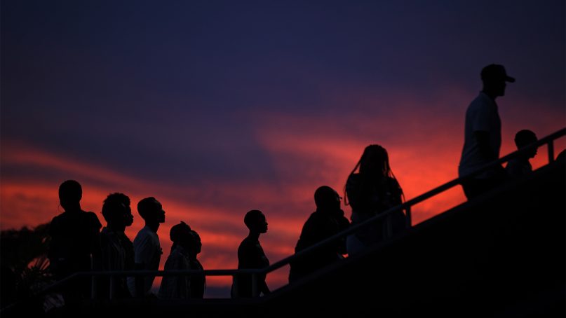 Rwandans arrive at dusk for a memorial service held at Amahoro stadium in the nation's capital, Kigali, on April 7, 2019. Rwanda is commemorating the 25th anniversary of when the country descended into an orgy of violence in which up to 1 million Tutsis and moderate Hutus were massacred by the majority Hutu population over a 100-day period in what was the worst genocide in recent history. (AP Photo/Ben Curtis)