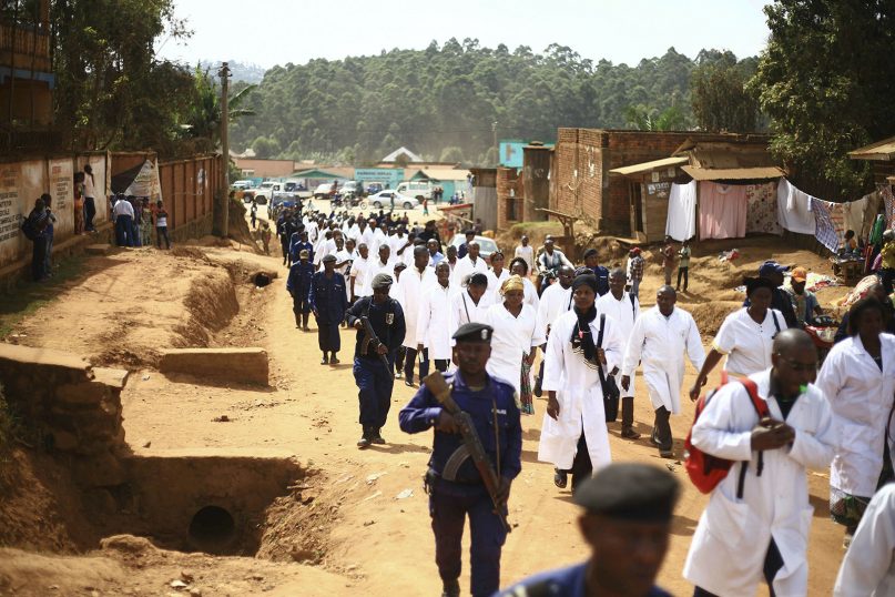 Doctors and health workers march in the eastern Congo town of Butembo on April 24, 2019, after attackers shot and killed an epidemiologist from Cameroon who was working for the World Health Organization. Doctors at the epicenter of Congo's Ebola crisis are threatening to go on strike indefinitely if health workers are attacked again. (AP Photo/Al-hadji Kudra Maliro)