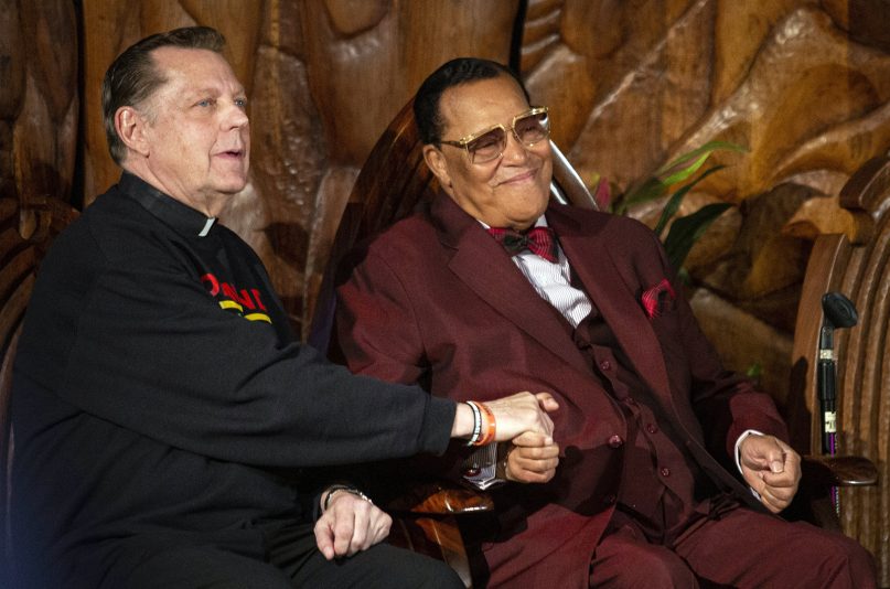 Rev. Michael Pfleger, left, sits next to Minister Louis Farrakhan, of the Nation of Islam, before they both speak at Saint Sabina Church, Thursday night, May 9, 2019, in Chicago. (Ashlee Rezin/Chicago Sun-Times via AP)
