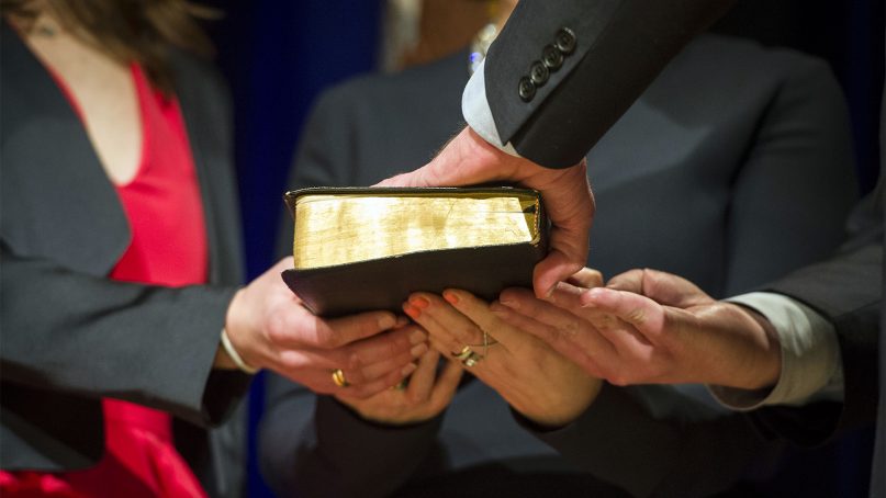 A hand on a Bible to take an oath. Photo by Petty Officer 2nd Class Sean Hurt/DoD