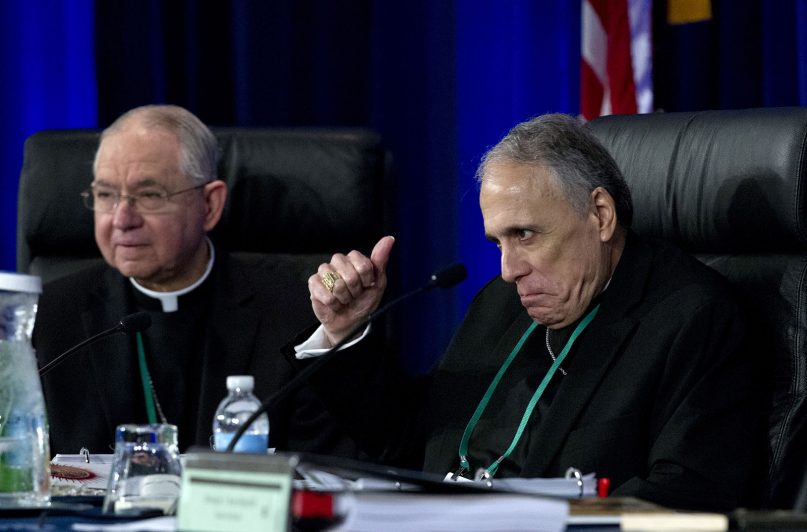 Cardinal Daniel DiNardo of the Archdiocese of Galveston-Houston, right, president of the United States Conference of Catholic Bishops, accompanied by Jose Gomez, archbishop of Los Angeles, makes a gesture before the morning prayer during the United States Conference of Catholic Bishops, 2019 spring meetings in Baltimore, Tues., June 11, 2019. (AP Photo/Jose Luis Magana)