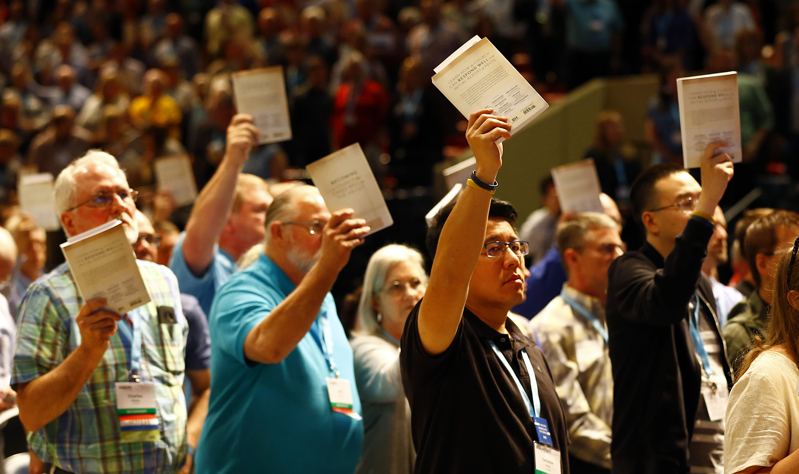 Messengers hold up SBC abuse handbooks while taking a challenge to stop sexual abuse during the annual meeting of the Southern Baptist Convention at the Birmingham-Jefferson Convention Complex, June 12, 2019, in Birmingham, Alabama. RNS photo by Butch Dill