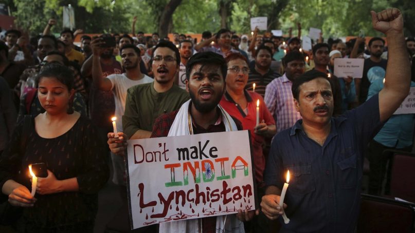 Indian protesters shout slogans as they hold placards and candles during a protest condemning recent mob lynching of Muslim youth Tabrez Ansari in Jharkhand state, in New Delhi, India, Wednesday, June 26, 2019. Since Prime Minister Narendra Modi took the helm of the Indian government, Hindu mobs have lynched dozens of people, mainly Muslims and lower-caste Dalits. (AP Photo/Altaf Qadri)