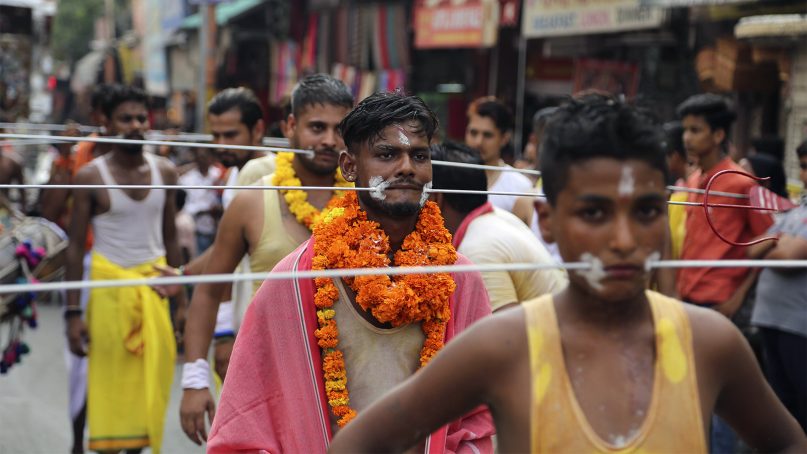 Devotees, with steel tridents pierced through their cheeks as part of a ritual, prepare to start an annual pilgrimage to the temple of Hindu goddess Sheetla Mata in Jammu, India, on July 21, 2019. (AP Photo/Channi Anand)