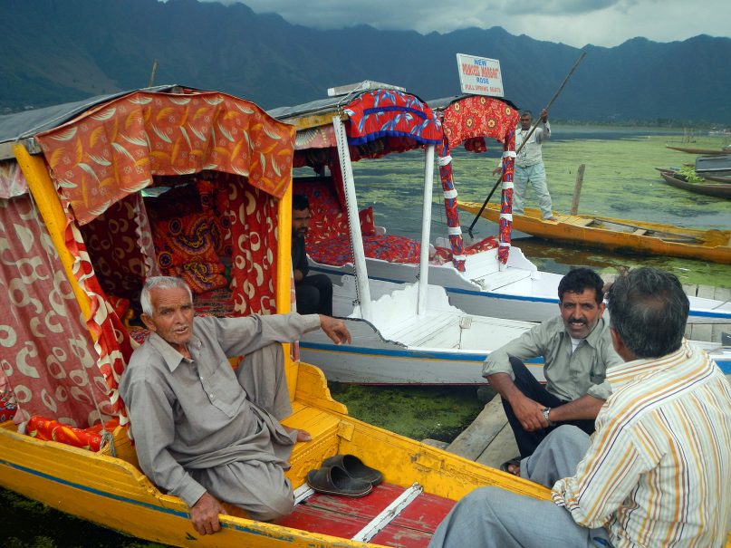Boatmen discuss the sad state of the weed-clogged Dal Lake in Srinagar, India, on June 24, 2019. RNS photo by Priyadarshini Sen