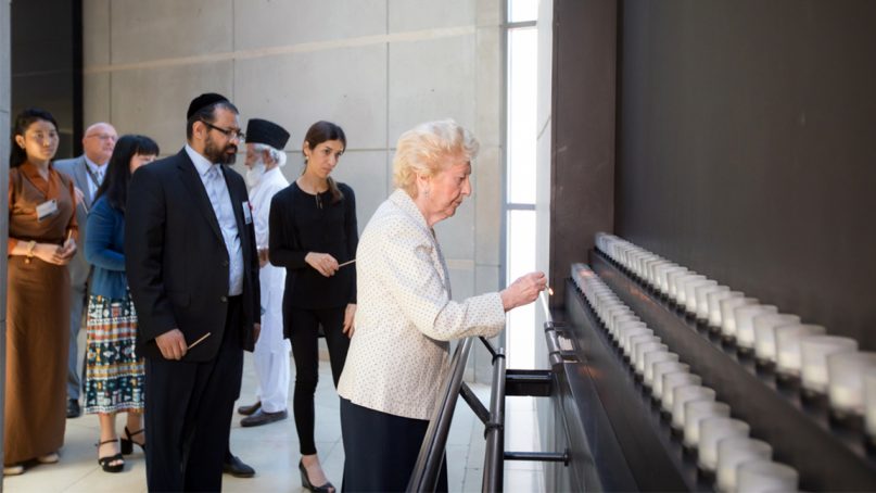 Holocaust survivor Irene Weiss lights a candle while other survivors of religious persecution look on after a tour of the permanent exhibition at the U.S. Holocaust Memorial Museum in Washington, D.C., on July 15, 2019. Photo by the U.S. Holocaust Memorial Museum/Creative Commons