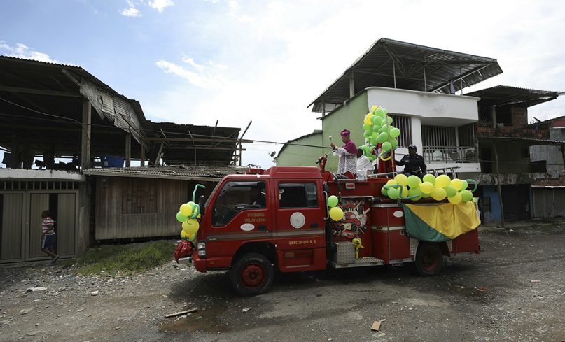 Catholic Bishop Ruben Dario Jaramillo Montoya rides on a fire truck sprinkling holy water, in Buenaventura, Colombia, on July 13, 2019. Jaramillo traveled on a fire truck to some of Buenaventura's most crime-ridden neighborhoods on Saturday, sprinkling water that he had blessed in what he called an attempt to thwart drug trafficking gangs and other illegal groups. (AP Photo/Fernando Vergara)
