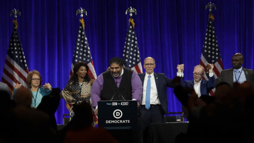 Democratic National Committee members join hands as Rev. Dr. William Barber II speaks Friday, Aug. 23, 2019, in San Francisco. More than a dozen Democratic presidential hopefuls are making their way to California to curry favor with national party activists from around the country. Democratic National Committee members will hear Friday from top contenders, including Elizabeth Warren, Kamala Harris and Bernie Sanders. (AP Photo/Ben Margot)