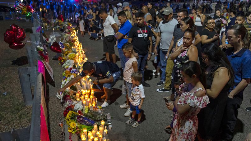 People gather at makeshift memorial for the victims of Saturday's mass shooting at a shopping complex in El Paso, Texas, on Aug. 4, 2019. (AP Photo/Andres Leighton)