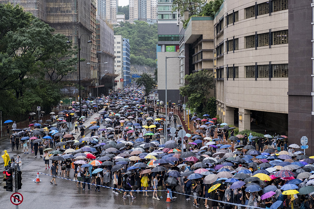 Tens of thousands of people march through rain in Hong Kong on Aug. 25, 2019. The end of the march resulted in some of the most violent clashes between the protesters and the riot police to date. Protesters threw bricks and petrol bombs at the police who responded with tear gas, rubber bullets and finally two water cannons. RNS photo by Alexandra Radu
