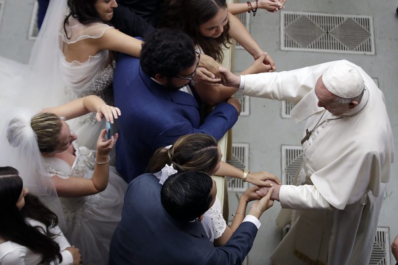 Pope Francis blesses newly married couples at the end of his weekly general audience in the Paul VI Hall at the Vatican, on Aug. 21, 2019. (AP Photo/Alessandra Tarantino)