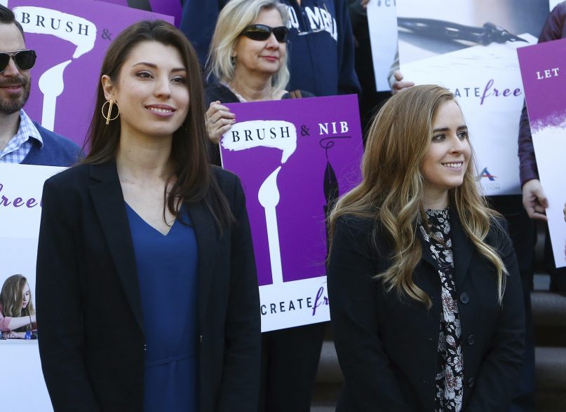 FILE - This Jan. 22, 2019 file photo shows Christian artists Joanna Duka, front left, and Breanna Koski, front right, outside the Arizona Supreme Court after justices heard arguments over Phoenix's anti-discrimination ordinance that bars businesses from refusing service to same-sex couples for religion reasons. Duka and Koski, who operate a business that makes invitations and other wedding-related items, had challenged the constitutionality of the ordinance. On Monday, Sept. 16, 2019 the state Supreme Court said the free speech rights of Duka and Koski were violated by the ordinance. (AP Photo/Ross D. Franklin,File)