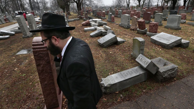 Rabbi Hershey Novack walks by vandalized tombstones at Chesed Shel Emeth Cemetery on Feb. 21, 2017, in St. Louis.  Photo courtesy of Robert Cohen/St. Louis Post-Dispatch