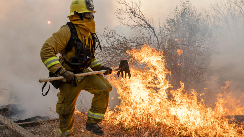 A firefighter from San Matteo helps fight the Kincade Fire in Sonoma County, Calif., on Sunday, Oct. 27, 2019. (AP Photo/Ethan Swope)