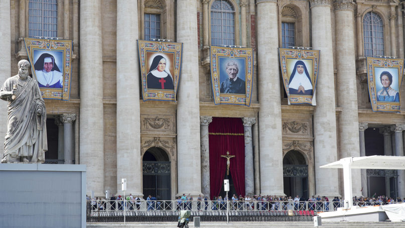 Tapestries hanging from the facade of St. Peter's Basilica portray from left; Dulce Lopes Pontes, Giuseppina Vannini, John Henry Newman, Maria Teresa Chiramel Mankidiyan, and Margarita Bays, at the Vatican, on Oct. 11, 2019. The five will be declared saints by Pope Francis during a Canonization Mass on Sunday, Oct 13, 2019. (AP Photo/Andrew Medichini)