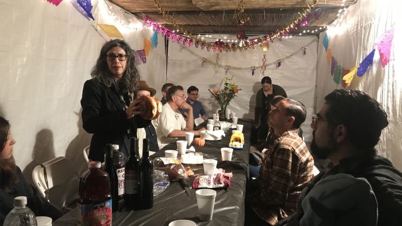 Rabbi Robin Podolski, left, blesses the bread during a feast inside a sukkah in the Los Angeles neighborhood of Boyle Heights, Sunday, Oct. 13, 2019. RNS photo by Alejandra Molina