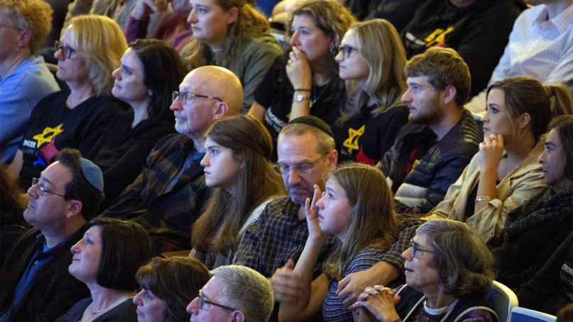 Community members react as they watch a video remembrance for victims of the Tree of Life synagogue attack during a one-year commemoration at Soldiers & Sailors Memorial Hall and Museum, Sunday, Oct. 27, 2019, in Pittsburgh. (AP Photo/Rebecca Droke)