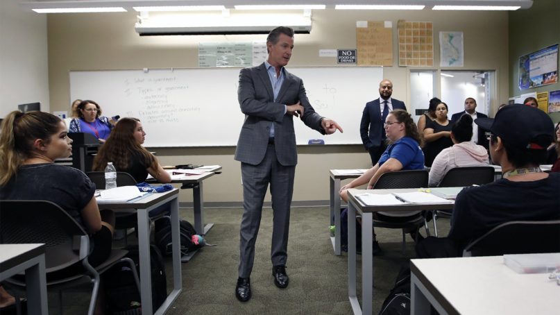 Gov. Gavin Newsom talks with students during a visit to a political science class at Cosumnes River College in Sacramento, Calif., on Aug. 27, 2019. Newsom visited the class and toured the campus as he touted California's two years of free community college tuition for first-time full-time students. (AP Photo/Rich Pedroncelli)