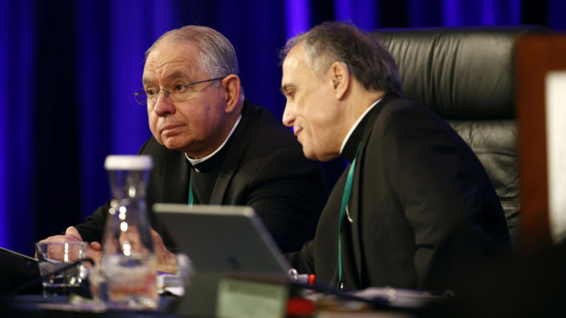 FILE - In this Monday, Nov. 12, 2018 file photo, Archbishop Jose Gomez of Los Angeles, vice president of the United States Conference of Catholic Bishops, left, sits with Cardinal Daniel DiNardo of the Archdiocese of Galveston-Houston, USCCB president, before the conference's annual fall meeting in Baltimore. Clergy sex abuse is once again on the agenda as U.S. Catholic bishops meet in November 2019, but so is a potentially historic milestone: Archbishop Gomez, an immigrant from Mexico, is widely expected to win election as the first Hispanic president of the bishops’ national conference. (AP Photo/Patrick Semansky)