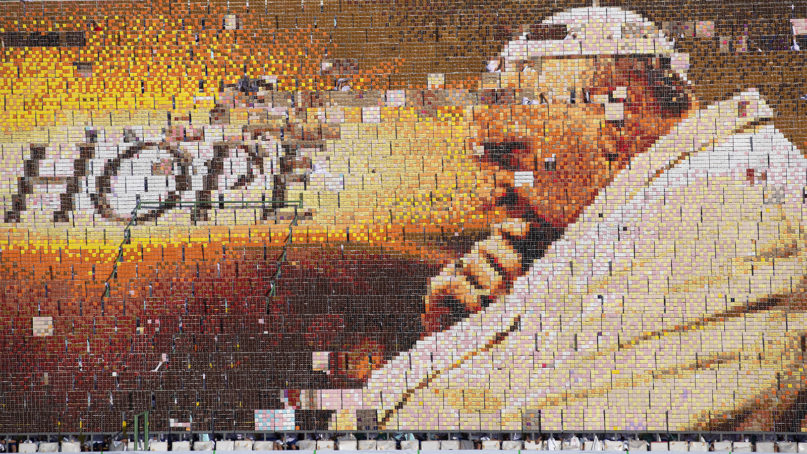 Students practice flipping boards with photos to reveal a full-mosaic portrait of Pope Francis before a Mass at National Stadium in Bangkok on Nov. 21, 2019. (AP Photo/Sakchai Lalit)