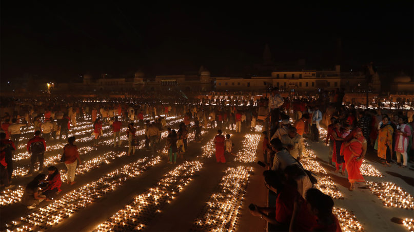 People light earthen lamps on the banks of the River Sarayu as part of Diwali celebrations in Ayodhya, India, Saturday, Oct. 26, 2019. The Hindu festival of lights, marked by lighting lamps and offering prayers to the goddess of wealth Lakshmi, was celebrated on Oct 27, 2019. (AP Photo/Rajesh Kumar Singh)