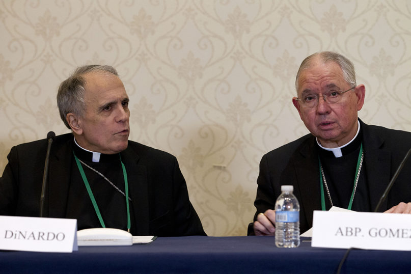 Cardinal Daniel DiNardo, left, of the Archdiocese of Galveston-Houston, and Jose Gomez, archbishop of Los Angeles, speak during a news conference at the United States Conference of Catholic Bishops' 2019 spring meetings in Baltimore, on June 11, 2019. (AP Photo/Jose Luis Magana)