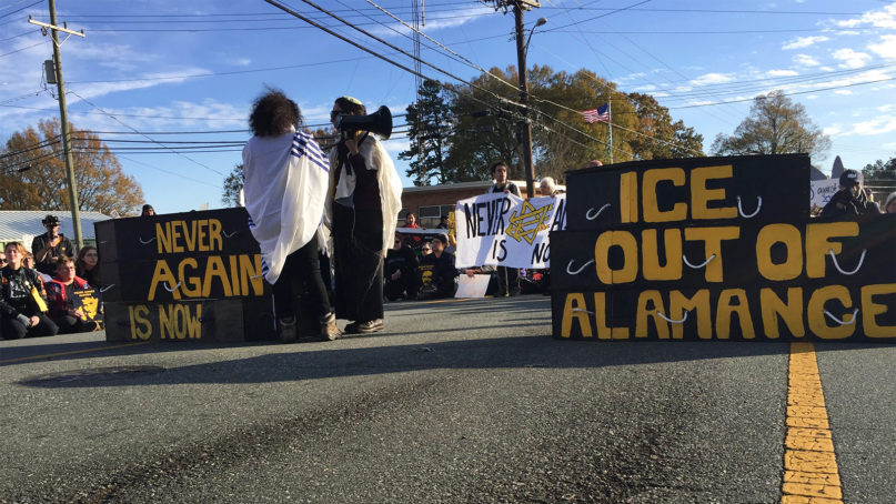 Activists from the Jewish group Never Again Action block a road with six empty black coffins at an ICE facility in Graham, North Carolina, on Sunday, Nov. 24, 2019, to protest the detention and deaths of immigrants in ICE custody. RNS photo by Yonat Shimron
