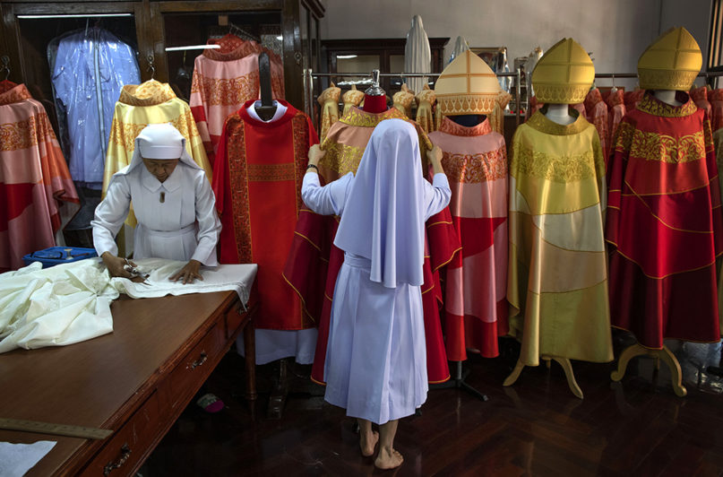 Sister Sukanya Sukchai, right, adjusts a newly made chasuble at a Catholic preparatory school in Bangkok, Thailand, Friday, Nov. 8, 2019. Seamstresses from the Congregation of the Sacred Heart of Jesus Sisters of Bangkok are studiously snipping and sewing, fashioning robes for the upcoming visit of Pope Francis. They’ve been working tirelessly, running up the ceremonial garments Pope Francis will wear during his four-day visit to Thailand later this month. (AP Photo/Gemunu Amarasinghe)