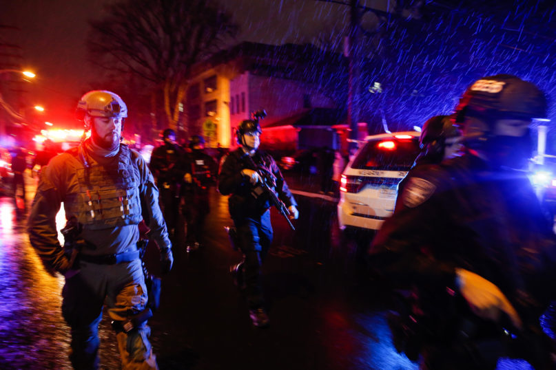Law enforcement personnel walk near the scene after a shooting Dec. 10, 2019, in Jersey City, New Jersey. (AP Photo/Eduardo Munoz Alvarez)