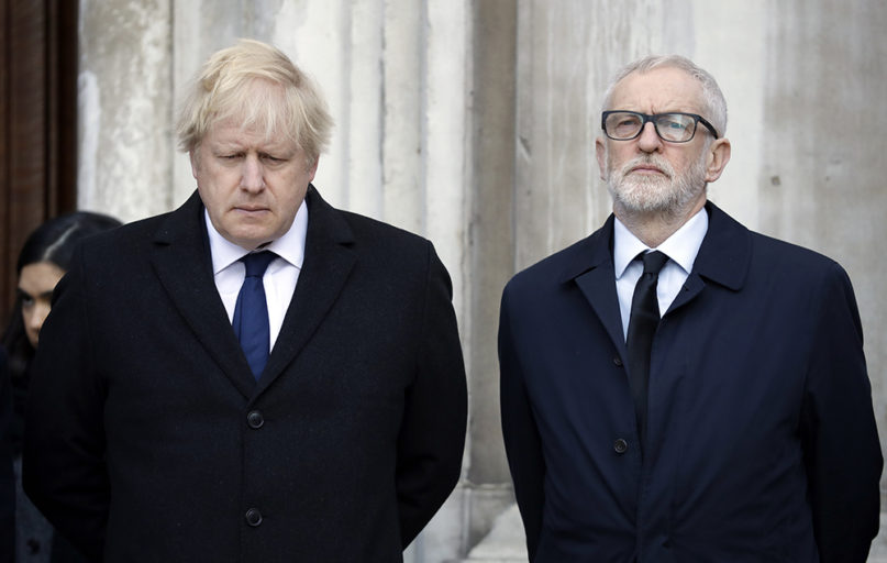 Britain's Prime Minister Boris Johnson, left, and Labour Party leader Jeremy Corbyn take part in a vigil at Guildhall Yard in London, Monday Dec. 2, 2019, to remember the London attack victims and honor members of the emergency services and bystanders who fought the attacker. London Bridge reopened to cars and pedestrians Monday, three days after a man previously convicted of terrorism offenses stabbed two people to death and injured three others before being shot dead by police. (AP Photo/Matt Dunham)
