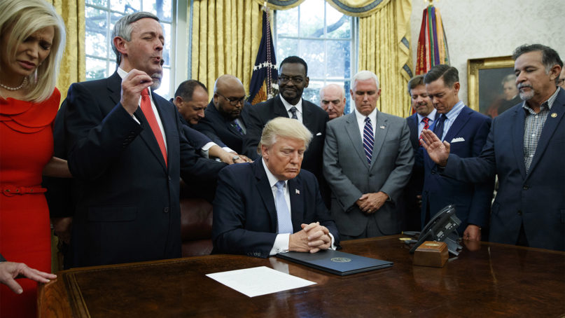 In this Sept. 1, 2017, file photo, religious leaders pray with President Donald Trump after he signed a proclamation for a national day of prayer to occur on Sunday, Sept. 3, 2017, in the Oval Office of the White House in Washington.  (AP Photo/Evan Vucci, File)