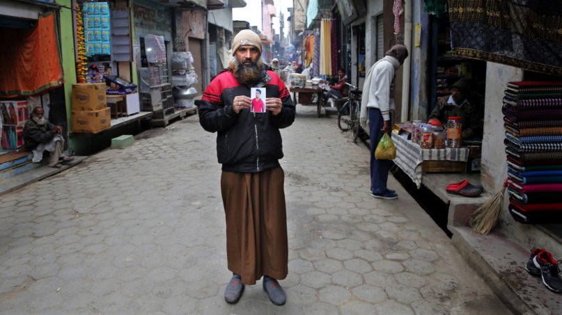 In this Wednesday, Dec. 25, 2019, photo, Arshad Hussain, father of Anas Ahmad who was killed allegedly in police firing during protests against Citizenship Amendment Act, holds a photograph of his son at the spot where he was killed, in Bijnor, India. Tens of thousands of people have taken to the streets to oppose a new law that grants a path to citizenship for immigrants of every religion except Islam. Many say the law, passed by Prime Minister Narendra Modi’s Hindu-nationalist government, discriminates against Muslims and undermines the country’s secular foundations. (AP Photo/Rajesh Kumar Singh)
