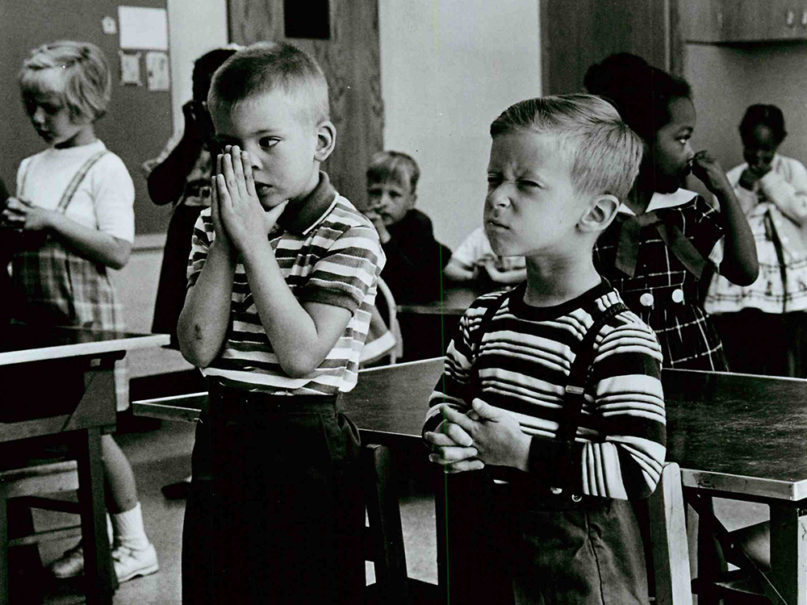 Public school students participate in school-organized prayer in New York in 1972. The initial U.S. Supreme Court ban on state-sponsored prayer came on June 25, 1962. State provisions for recitation of the Lord's Prayer and devotional reading of the Bible were barred a year later.  Voluntary prayer encouraged by school boards was outlawed in 1971. Times of voluntary prayer outside of class hours and conducted by students without any degree of encouragement from officials or teachers today takes place in some areas. RNS file photo