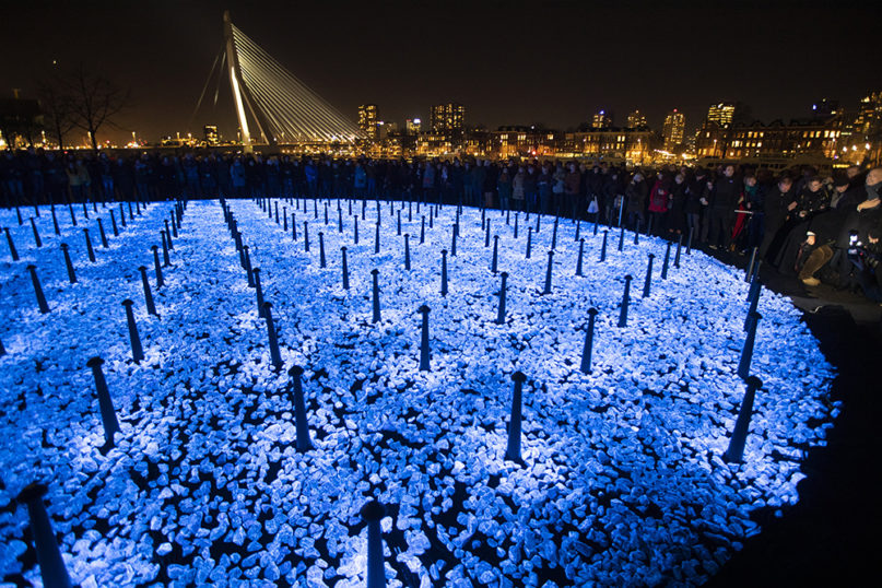 People attend a ceremony at the monument Levenslicht, or Light of Life, by artist Daan Roosegaarde, consisting of 104,000 light-emitting stones for the number of Dutch Holocaust victims, during the unveiling in Rotterdam, Netherlands, on Jan. 16, 2020, to mark the 75th anniversary of the liberation of the Auschwitz concentration and extermination camp. (AP Photo/Peter Dejong)