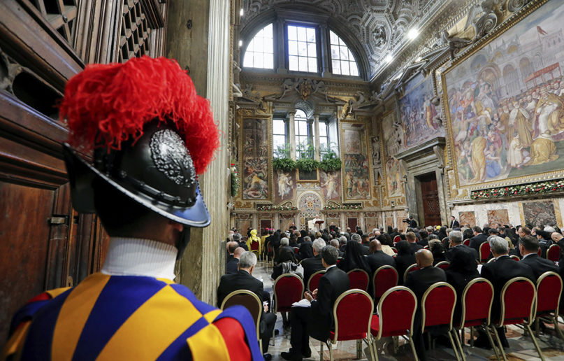A Vatican Swiss Guard stands at attention as Pope Francis delivers his speech during an audience with members of the diplomatic corps accredited to the Holy See, on the occasion of the traditional exchange of New Year greetings at the Vatican, on Jan. 9, 2020. (Remo Casilli/Pool photo Via AP)