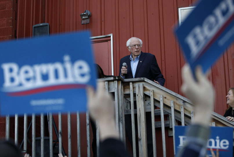 Democratic presidential candidate Sen. Bernie Sanders, I-Vt., accompanied by his wife, Jane O'Meara Sanders, right, speaks to an overflow crowd at a Super Bowl watch party campaign event on Feb. 2, 2020, in Des Moines, Iowa. (AP Photo/John Locher)