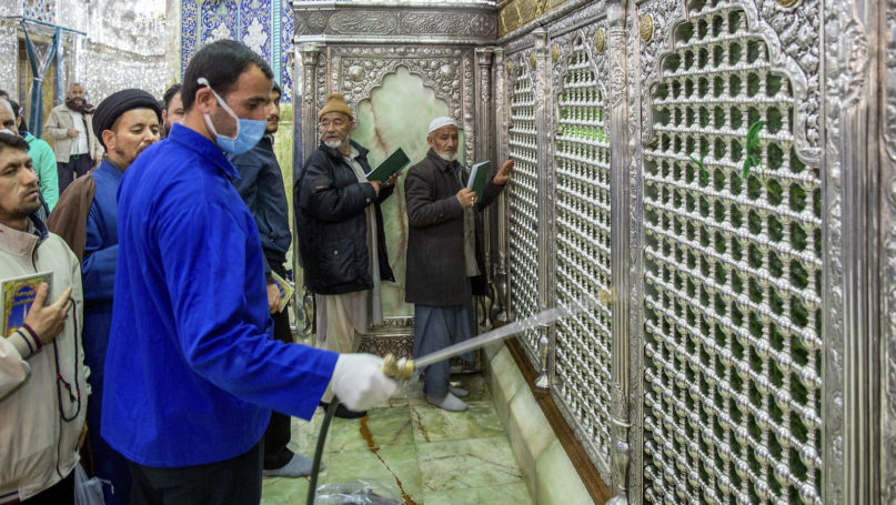 In this Feb. 24, 2020, photo, a man disinfects the shrine of St. Masoumeh against coronavirus in the city of Qom, 78 miles (125 kilometers) south of Iran’s capital, Tehran. Iran’s government said Monday that 12 people had died nationwide from the new coronavirus, rejecting claims of a much higher death toll of 50 by a lawmaker from the city of Qom that has been at the epicenter of the virus in the country. (Ahmad Zohrabi/ISNA via AP)