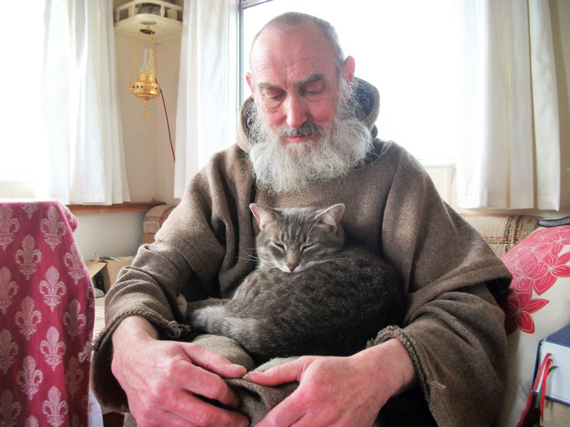 Hermit monk Stephen De Kerdrel sits with one of his cats on the island of Westray in Scotland. Courtesy photo