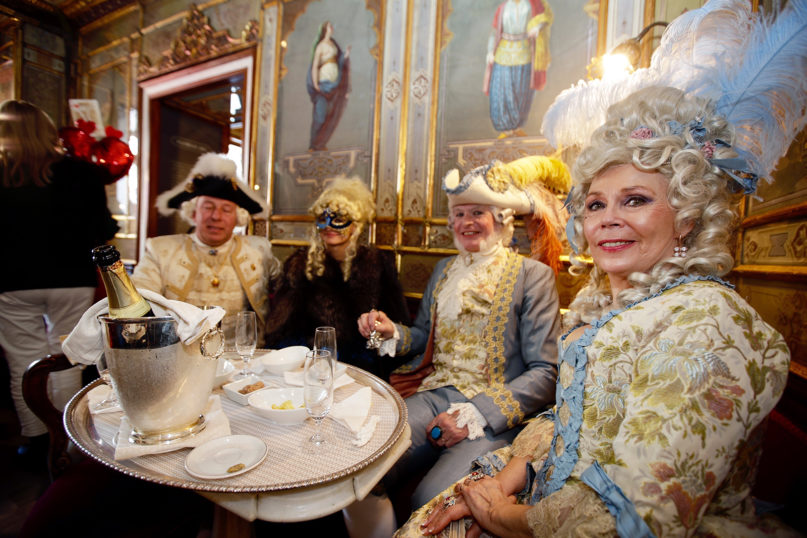 People wearing Carnevale costumes and masks gather at the historical Cafe Florian during Carnevale celebrations in Venice, Italy, on Feb. 16, 2020. The Venice Carnevale in the historical lagoon city attracts people from around the world. (AP Photo/ Luca Bruno)