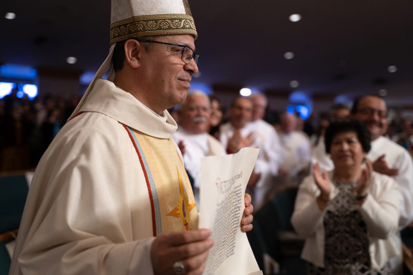 Bishop Alberto Rojas displays the apostolic mandate from Pope Francis during a Mass at St. Paul the Apostle Church on Feb. 24, 2020, in Chino Hills, California. Francis appointed Rojas as the new coadjutor bishop of the Diocese of San Bernardino. Photo courtesy of Diocese of San Bernardino