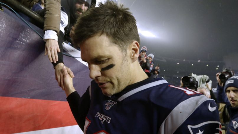 New England Patriots quarterback Tom Brady shakes hands with a fan as he leaves the field after losing an NFL wild-card playoff football game to the Tennessee Titans, Saturday, Jan. 4, 2020, in Foxborough, Mass. (AP Photo/Bill Sikes)